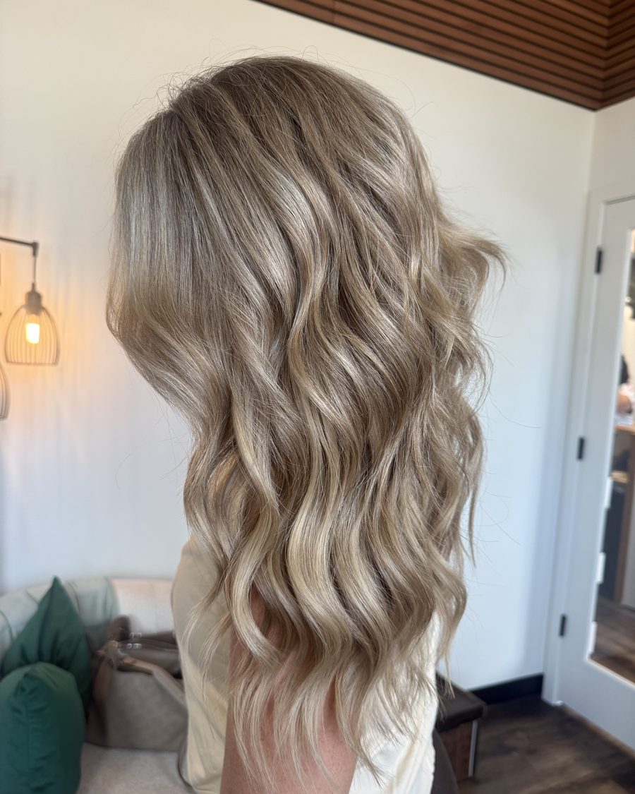 Dimensional bronde waves blended through hand-tied extensions, photographed in warm light at Emerald Salon & Suites