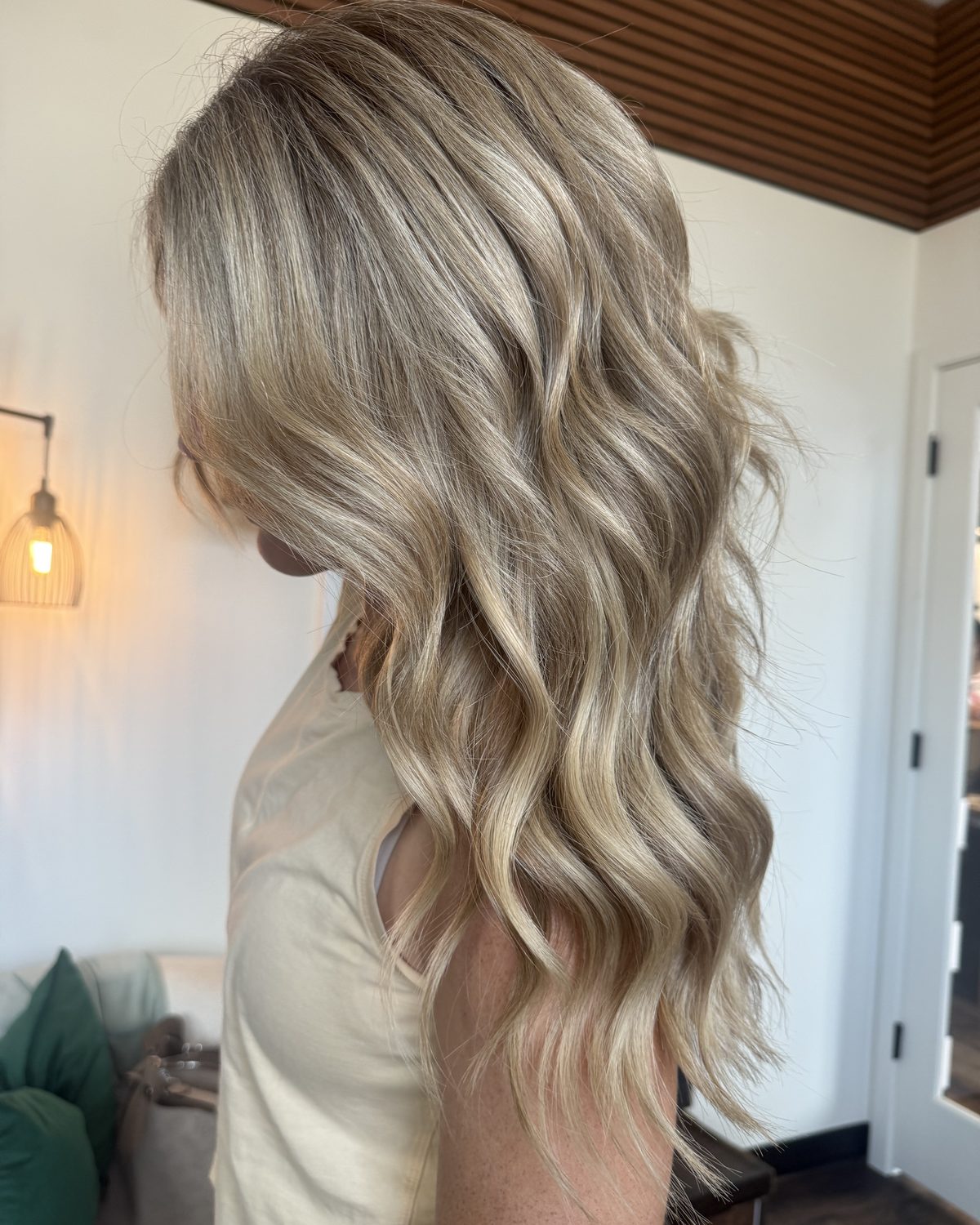 Long dimensional bronde waves after a hand-tied Invisible Bead Extensions install at Emerald Salon & Suites in Hiawatha, Iowa